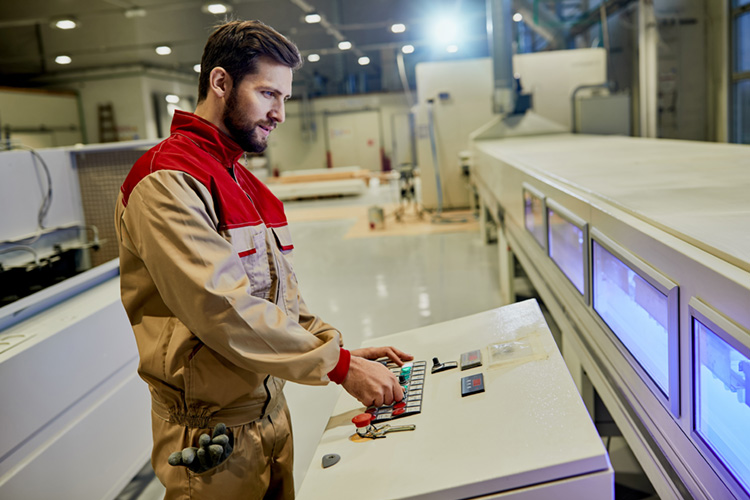 Travailleur faisant fonctionner une machine automatisée.